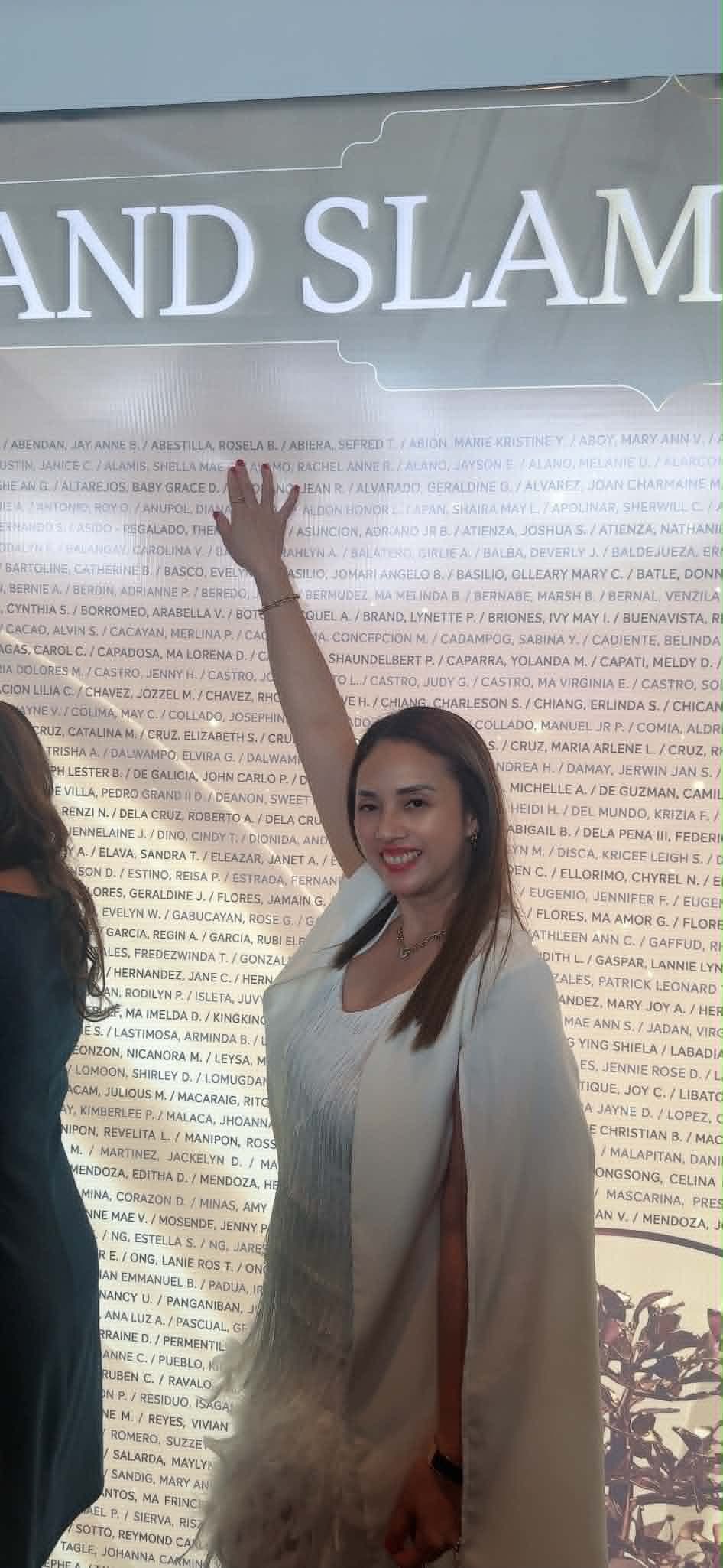 Ruth Abestilla beside the Sun Life Grand Slam recognition wall