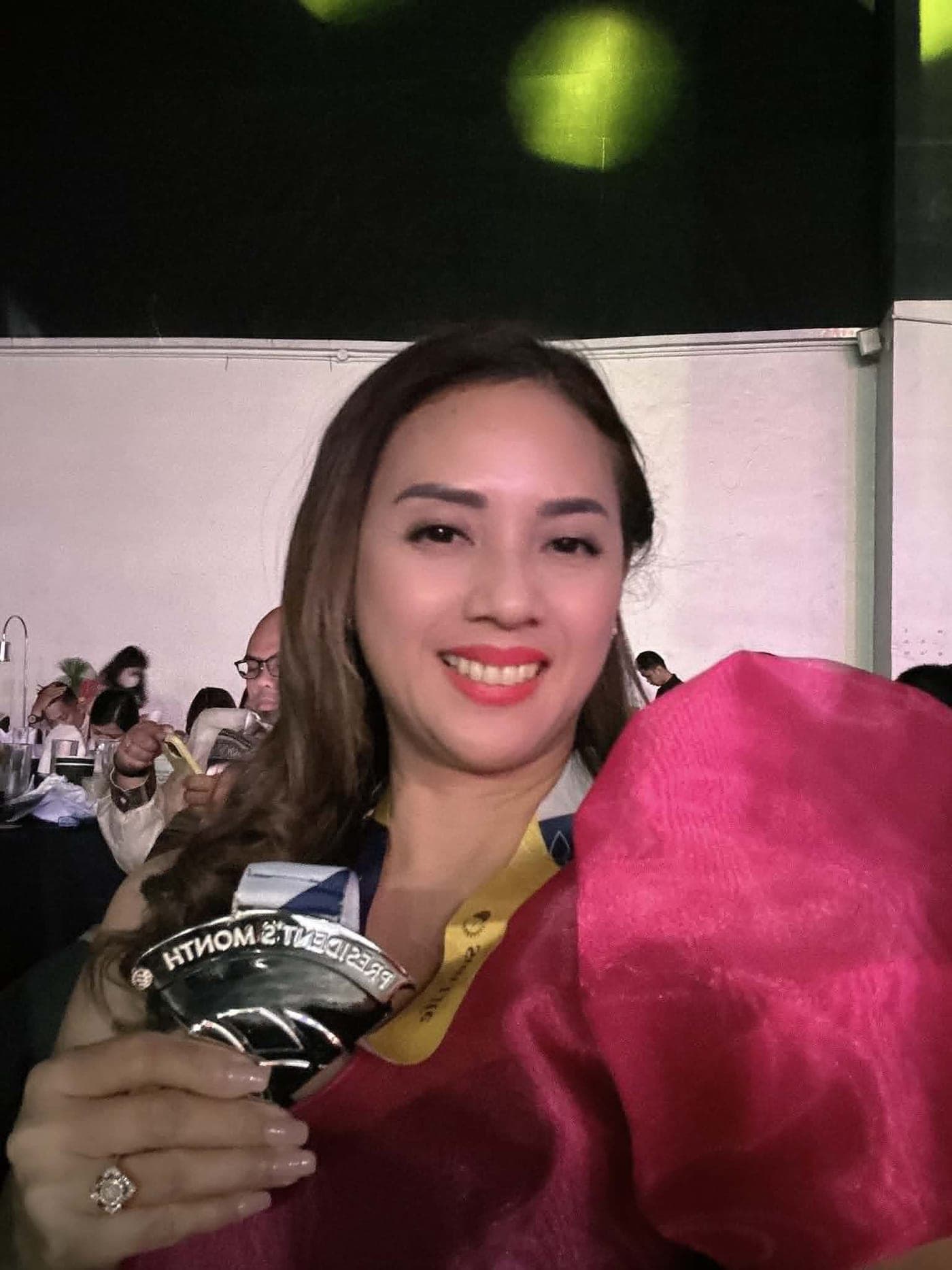 Ruth Abestilla holding a President's Club recognition medal